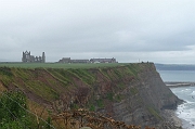 Mystieke ru�nes doemen op; de stad Whitby ligt achter de klif